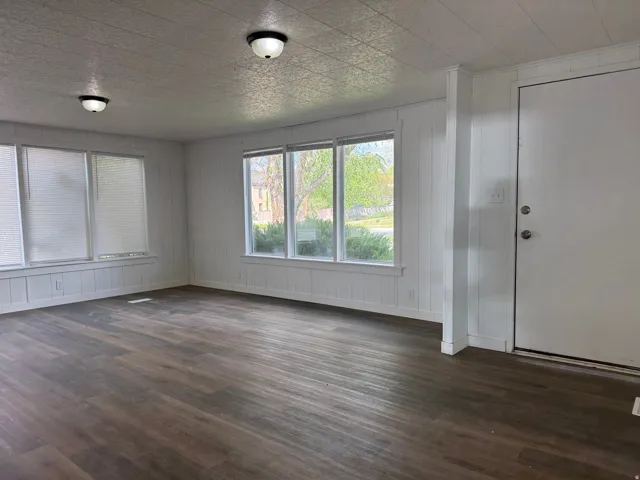 Entrance foyer featuring dark wood-type flooring and wooden walls