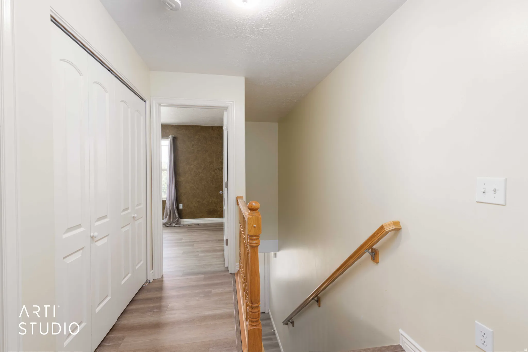 Hall with an upstairs landing and light wood-type flooring