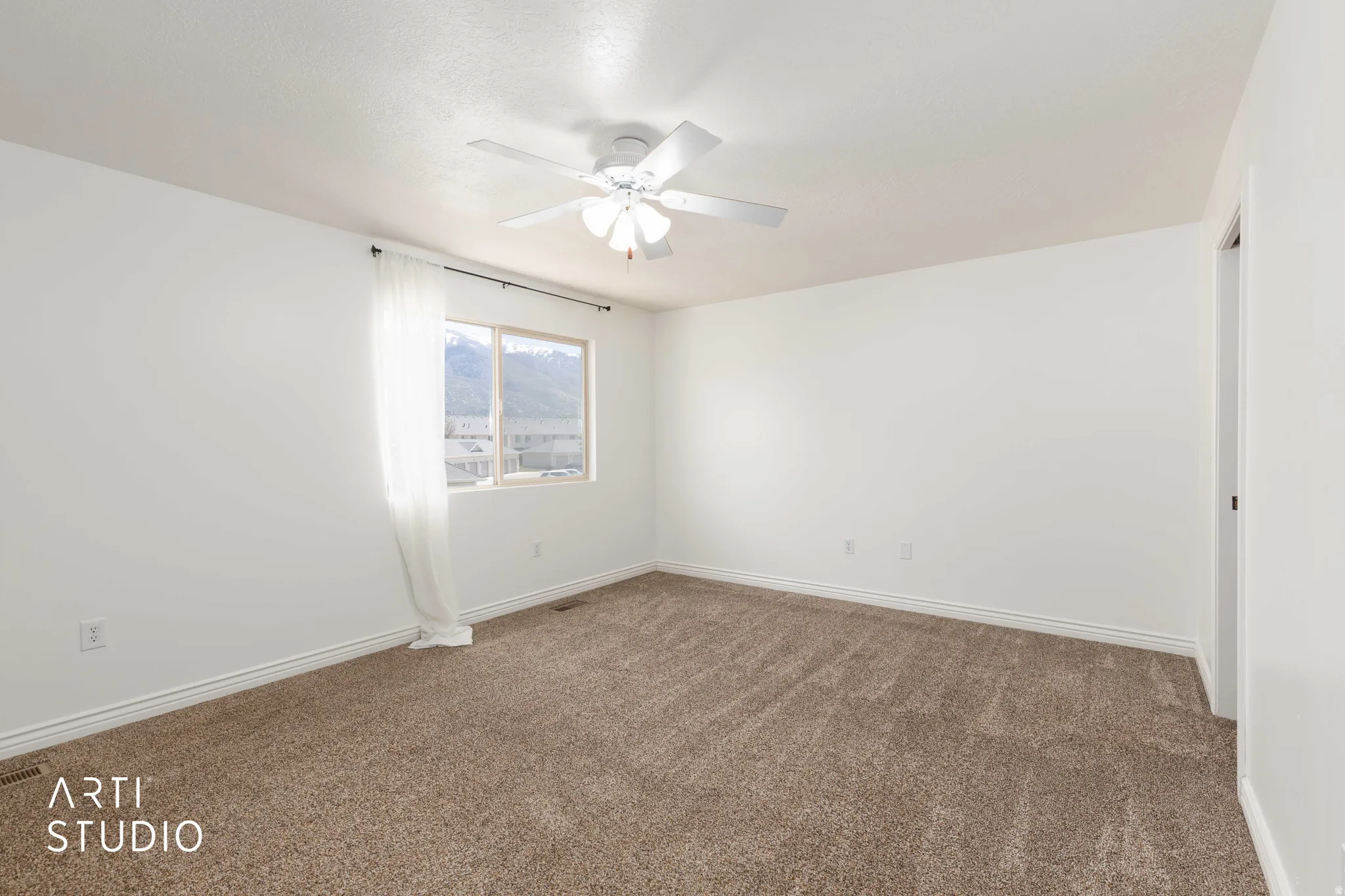 Unfurnished room featuring dark colored carpet and ceiling fan
