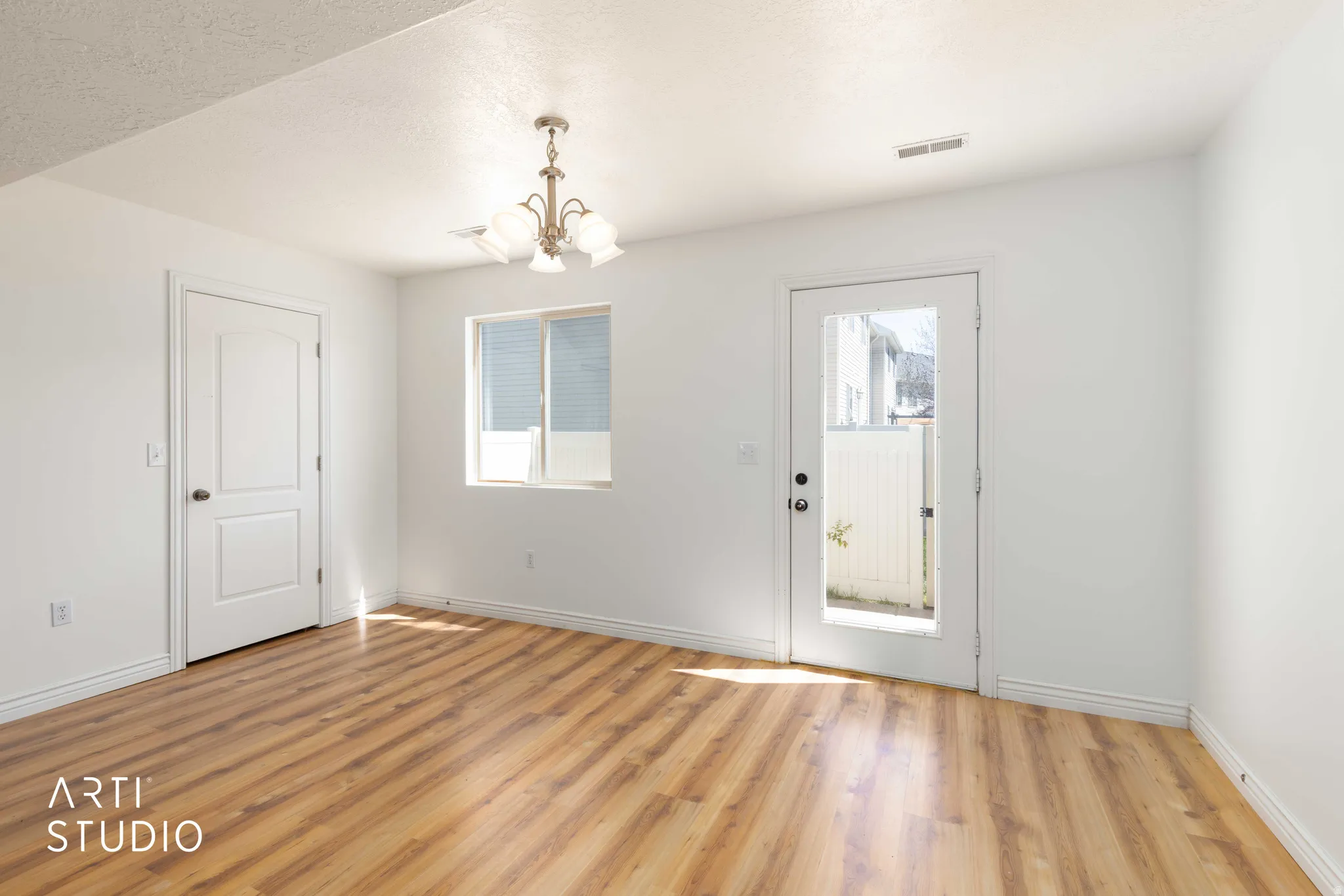 Entryway featuring a chandelier, light wood-style flooring, and a textured ceiling