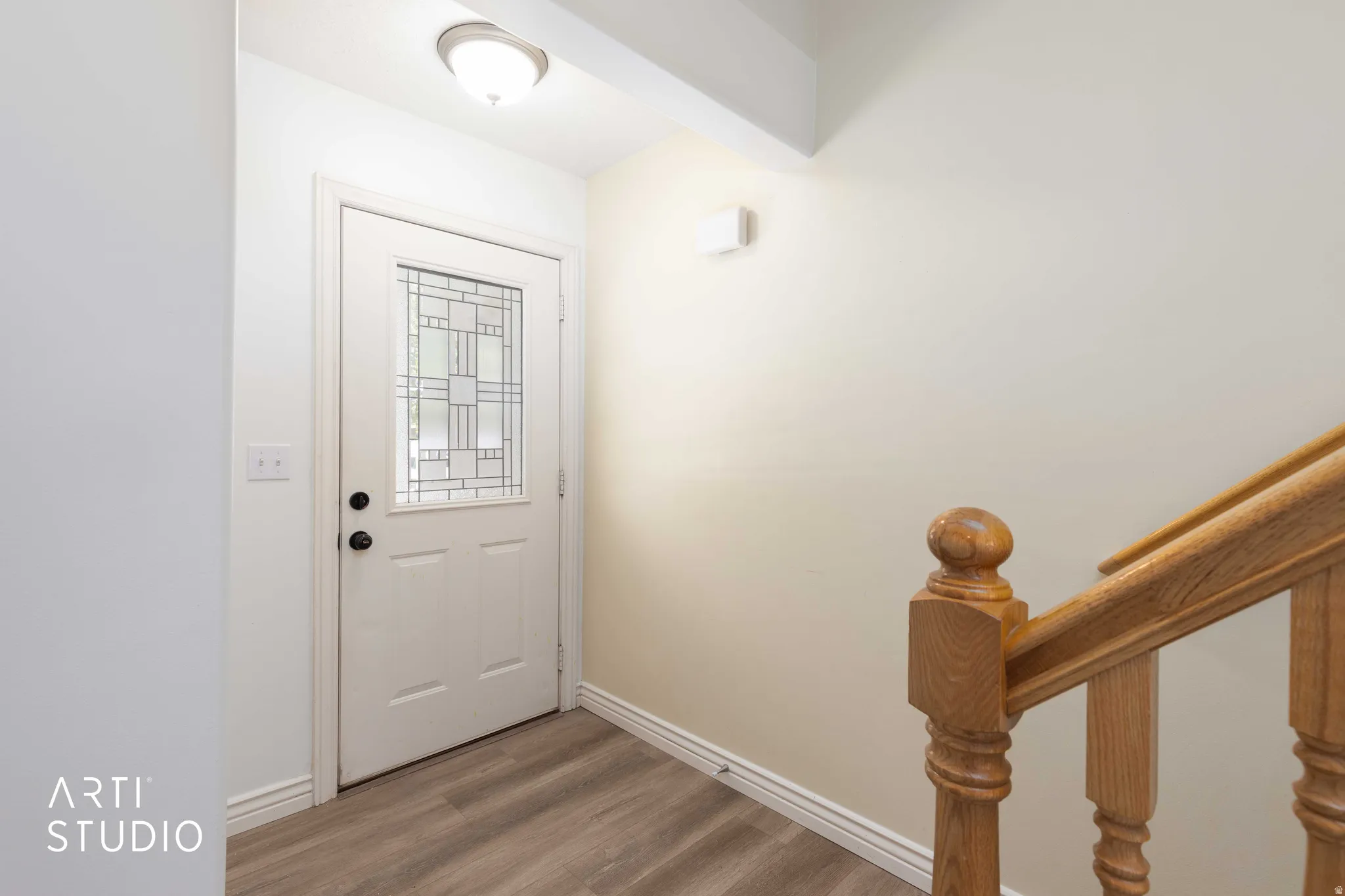 Doorway with wood finished floors and baseboards