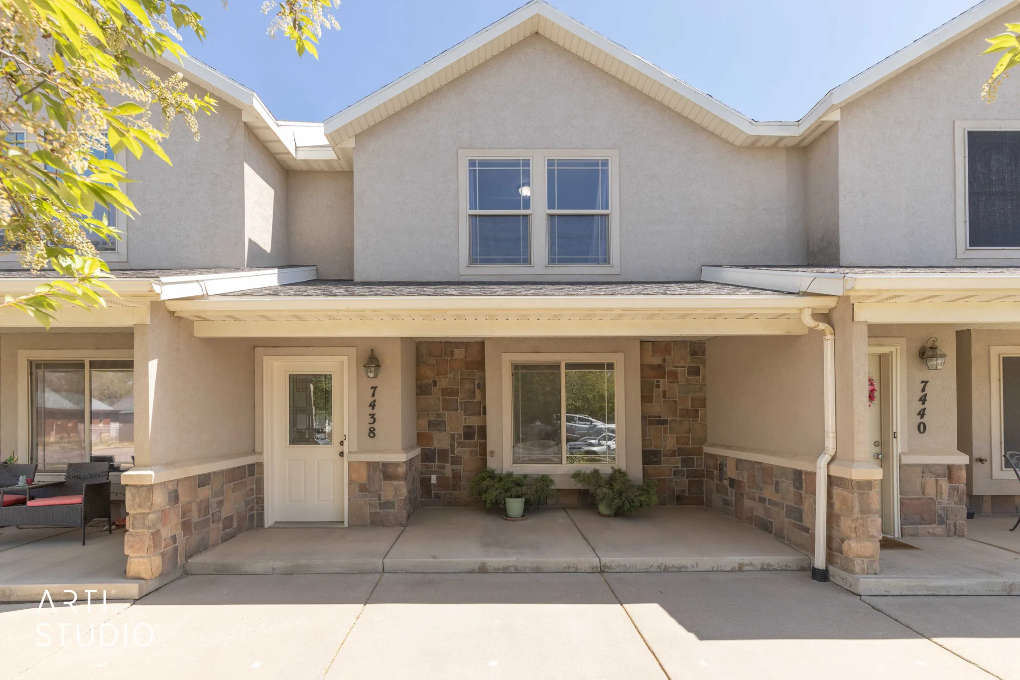 View of front of property with stone siding, covered porch, and stucco siding