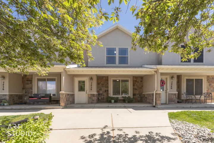 Traditional home featuring stone siding, stucco siding, and a porch