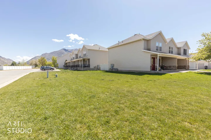 View of side of home featuring a mountain view, a patio, and stone siding