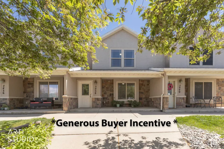Two-story exterior featuring stone veneer siding, covered front entryways, dual-pane windows, and concrete walkways