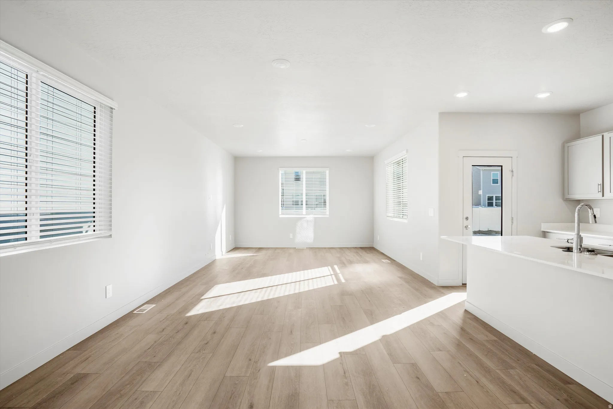 **DISCLAIMER** Interior package & color may vary. Unfurnished living room with light wood finished floors and recessed lighting