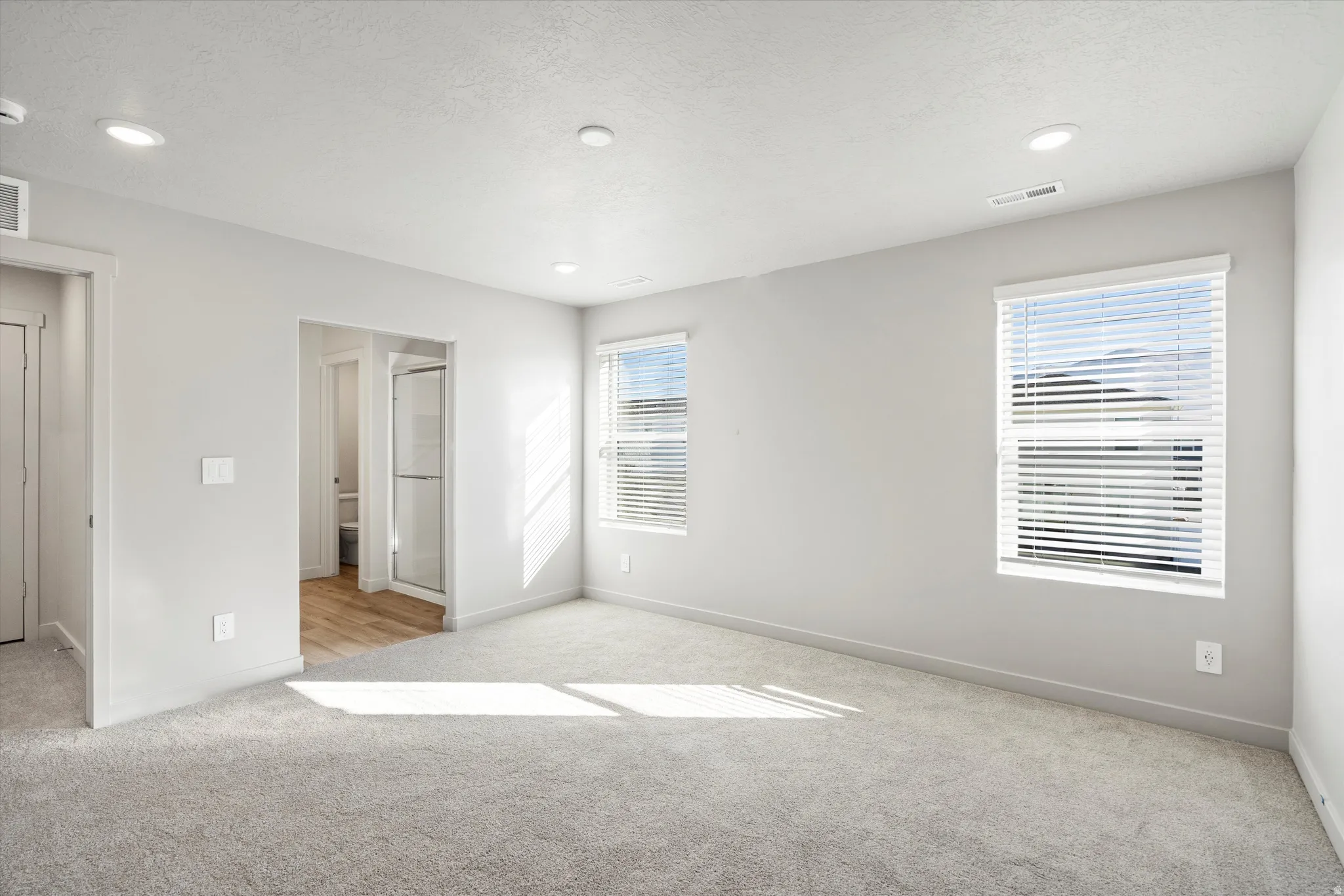 **DISCLAIMER** Interior package & color may vary. Unfurnished bedroom with light carpet, a textured ceiling, and recessed lighting