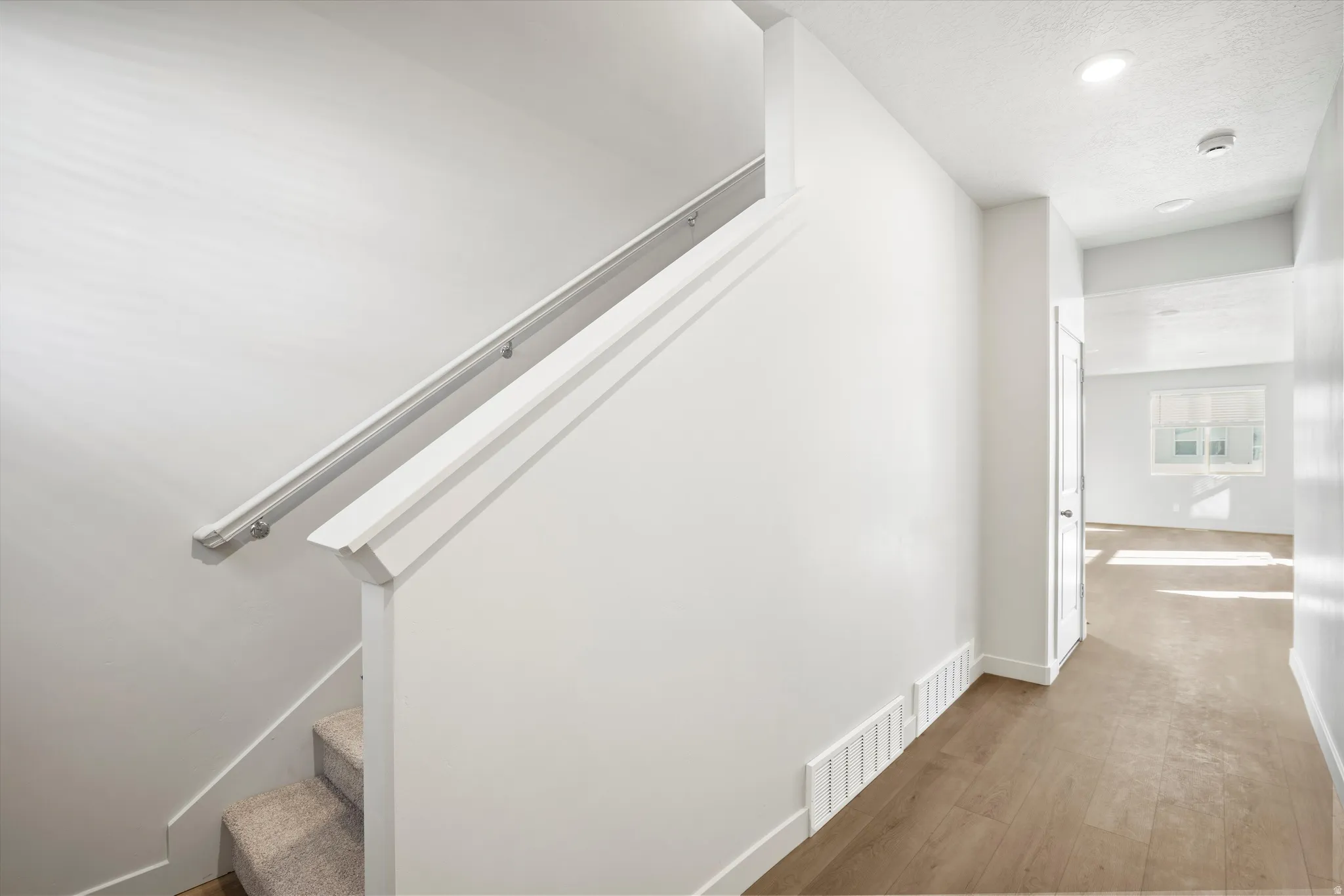 **DISCLAIMER** Interior package & color may vary. Stairway featuring wood finished floors and recessed lighting