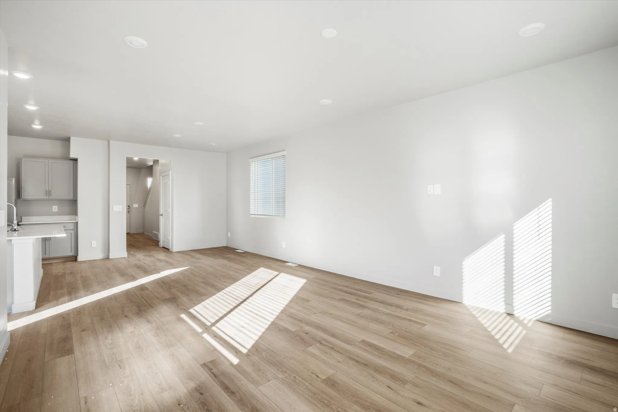 **DISCLAIMER** Interior package & color may vary. Unfurnished living room with light wood-style flooring and recessed lighting