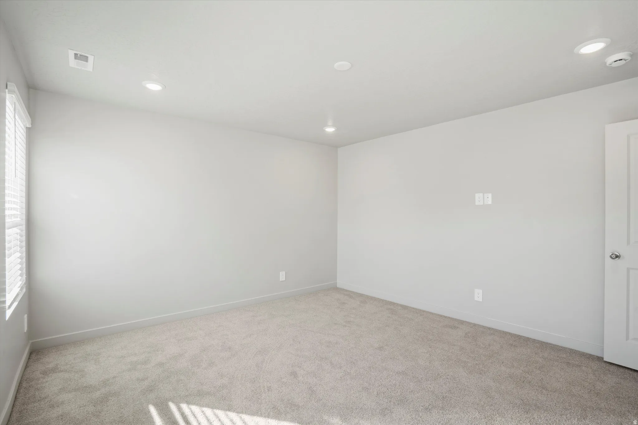 **DISCLAIMER** Interior package & color may vary. Carpeted spare room featuring recessed lighting and a smoke detector