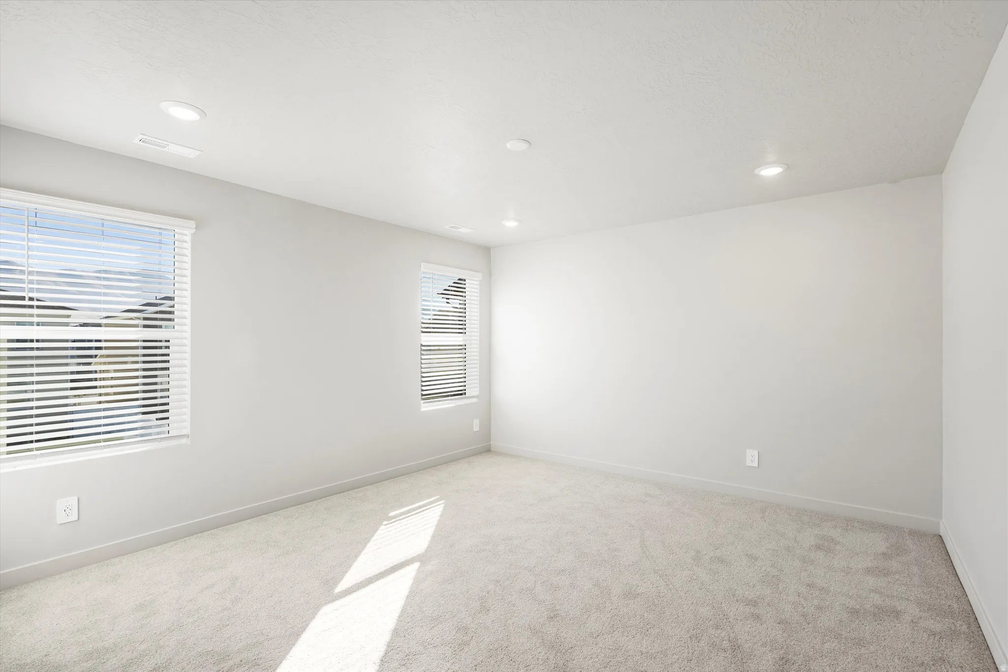 **DISCLAIMER** Interior package & color may vary. Spare room featuring light carpet and recessed lighting