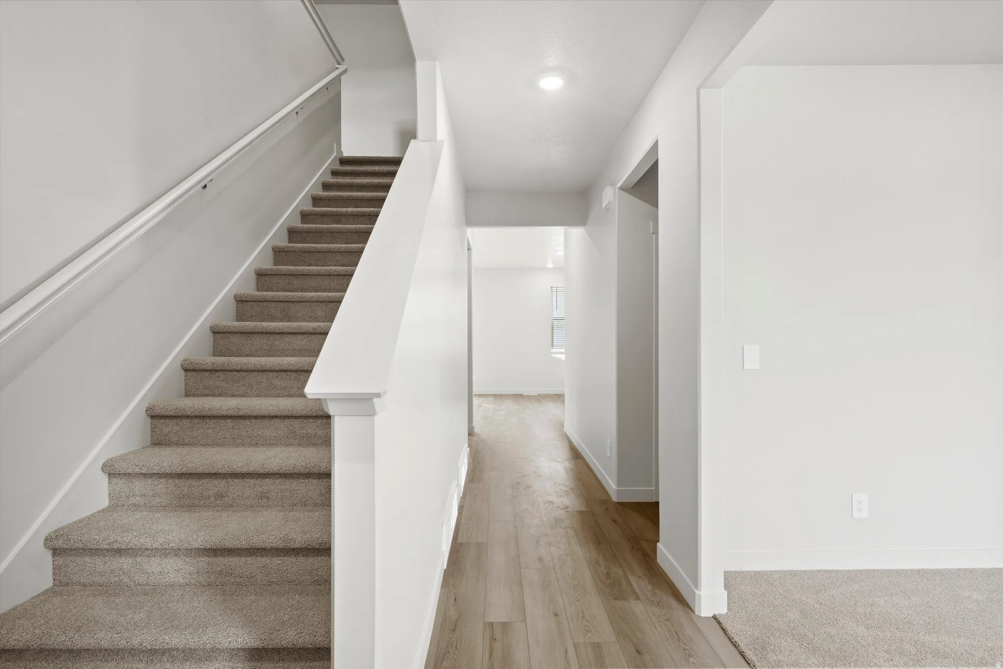 Stairway featuring wood finished floors and recessed lighting