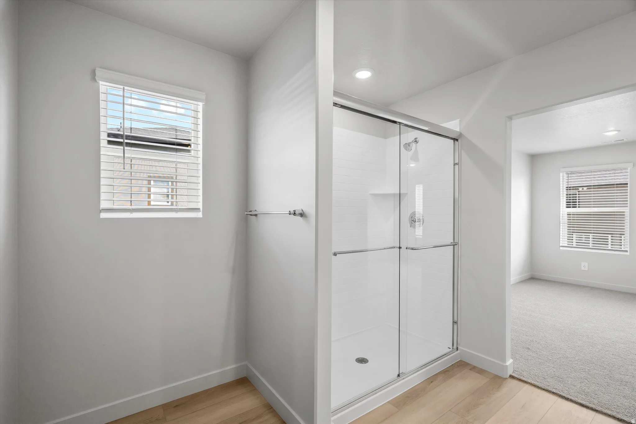 Full bath featuring a stall shower and light wood-style floors