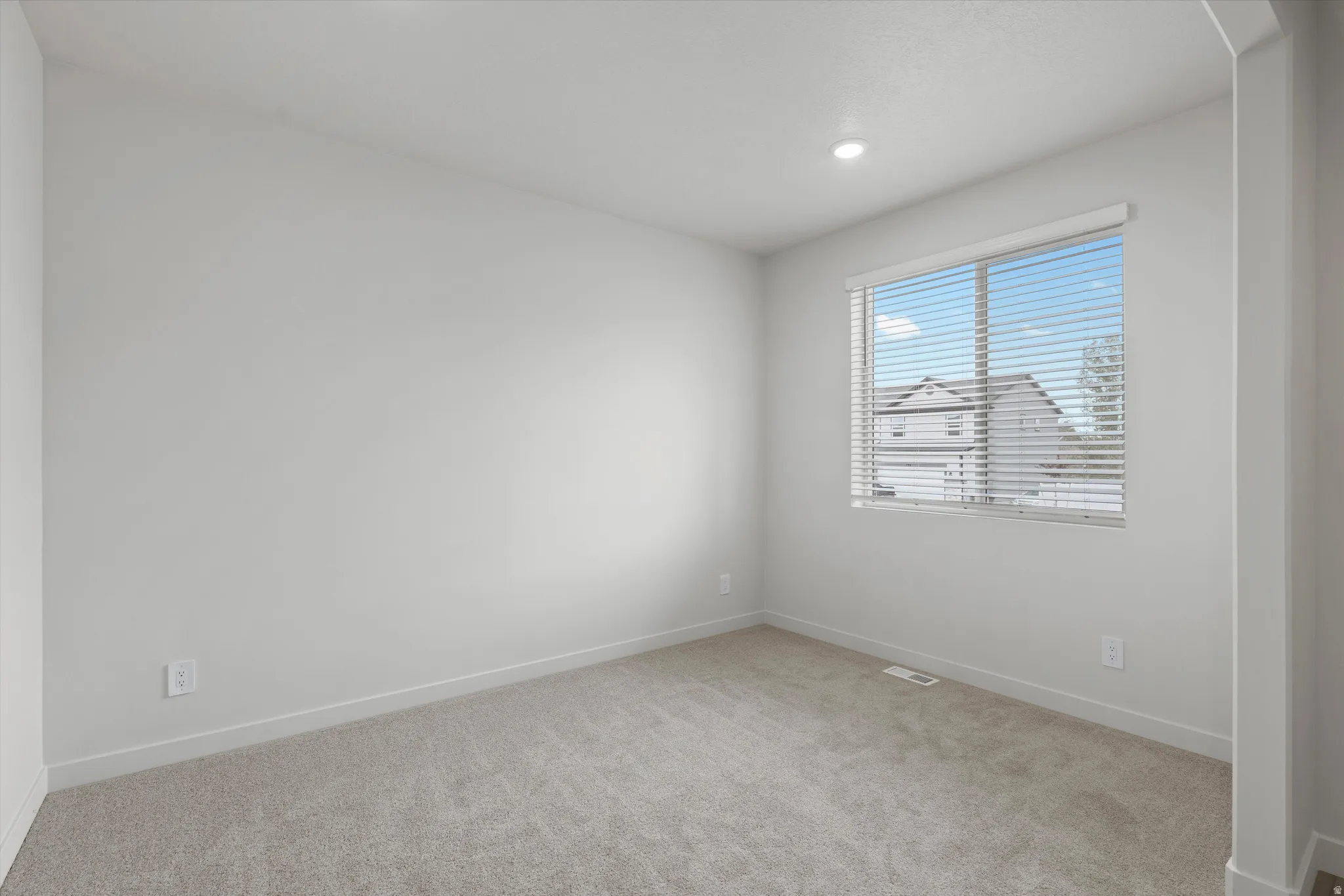 Unfurnished room featuring light colored carpet and baseboards