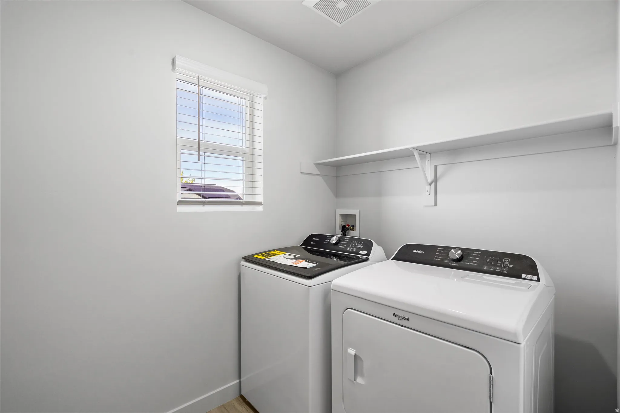 Laundry area featuring washing machine and dryer and baseboards