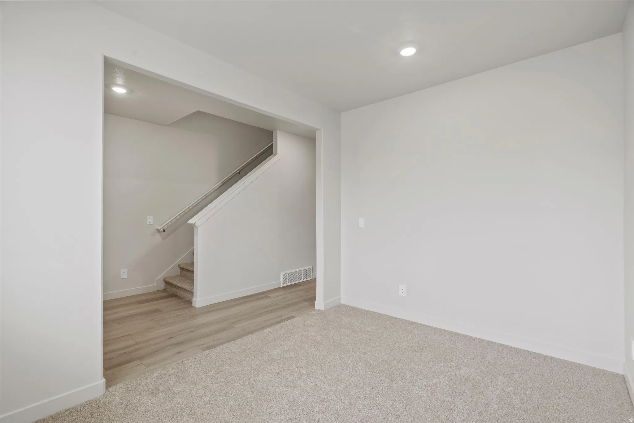 Below grade area featuring light colored carpet and recessed lighting