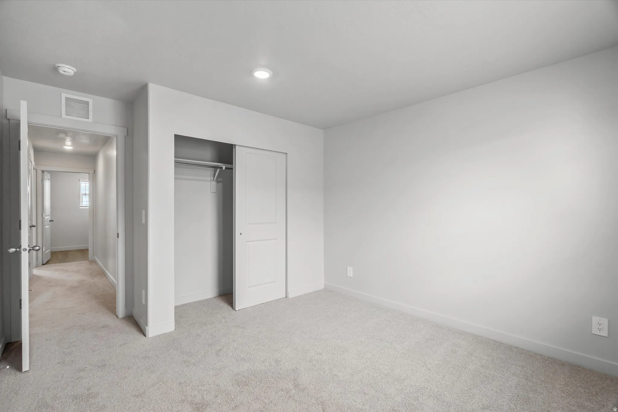 Unfurnished bedroom featuring light colored carpet and a closet