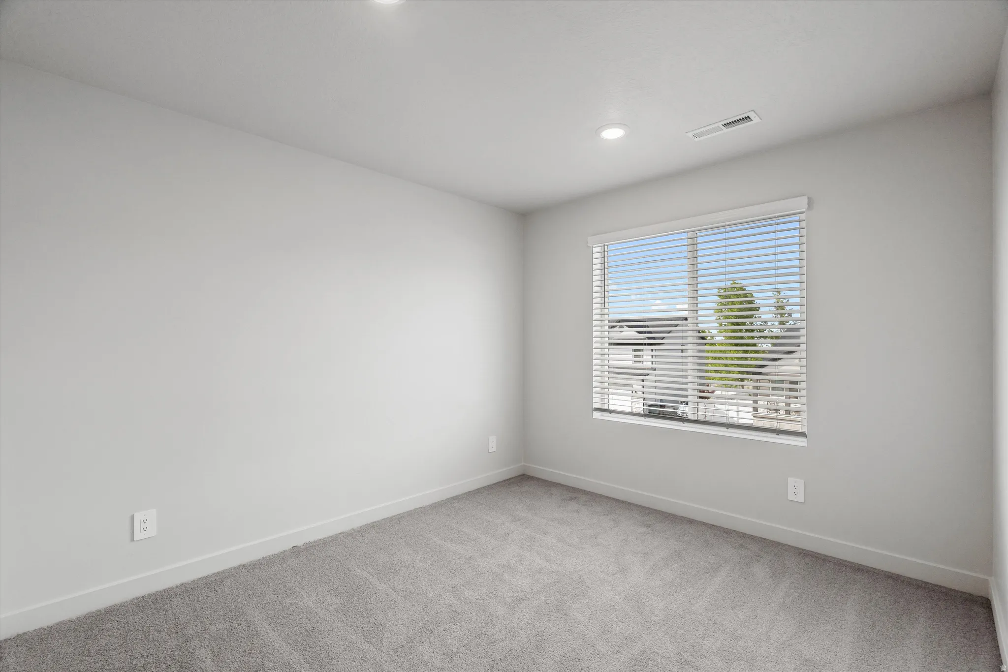 Spare room with baseboards and light carpet