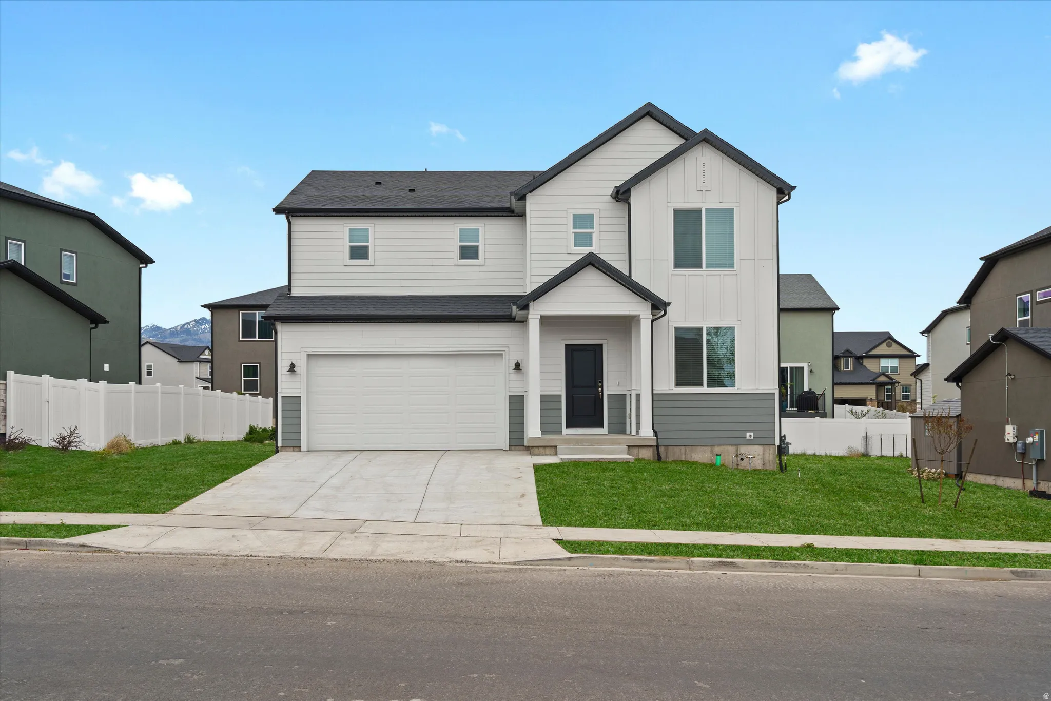 View of front facade with board and batten siding, concrete driveway, and an attached garage