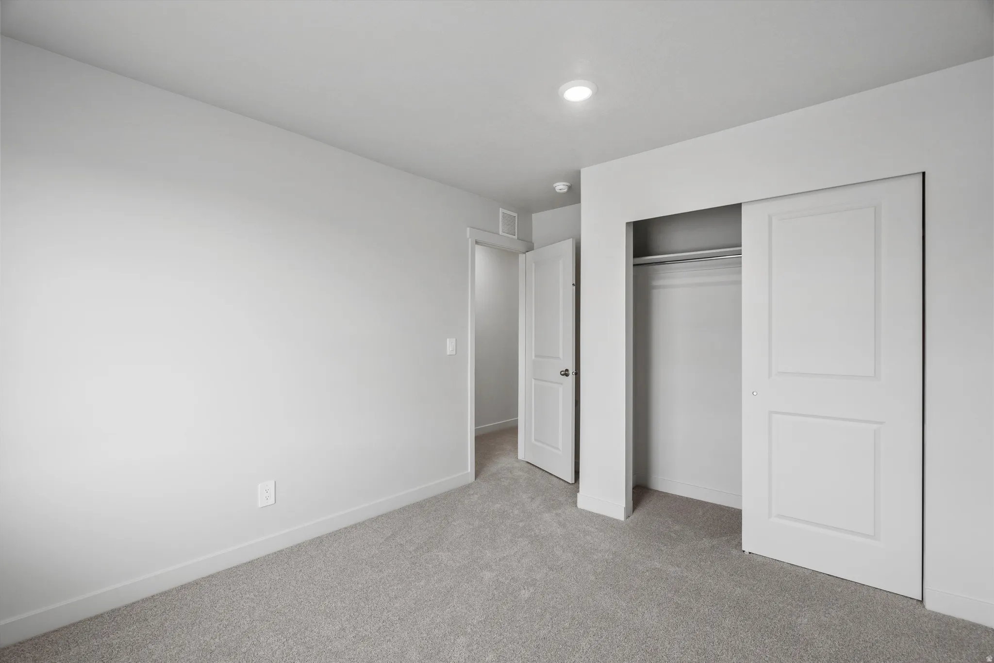 Unfurnished bedroom featuring light colored carpet and a closet