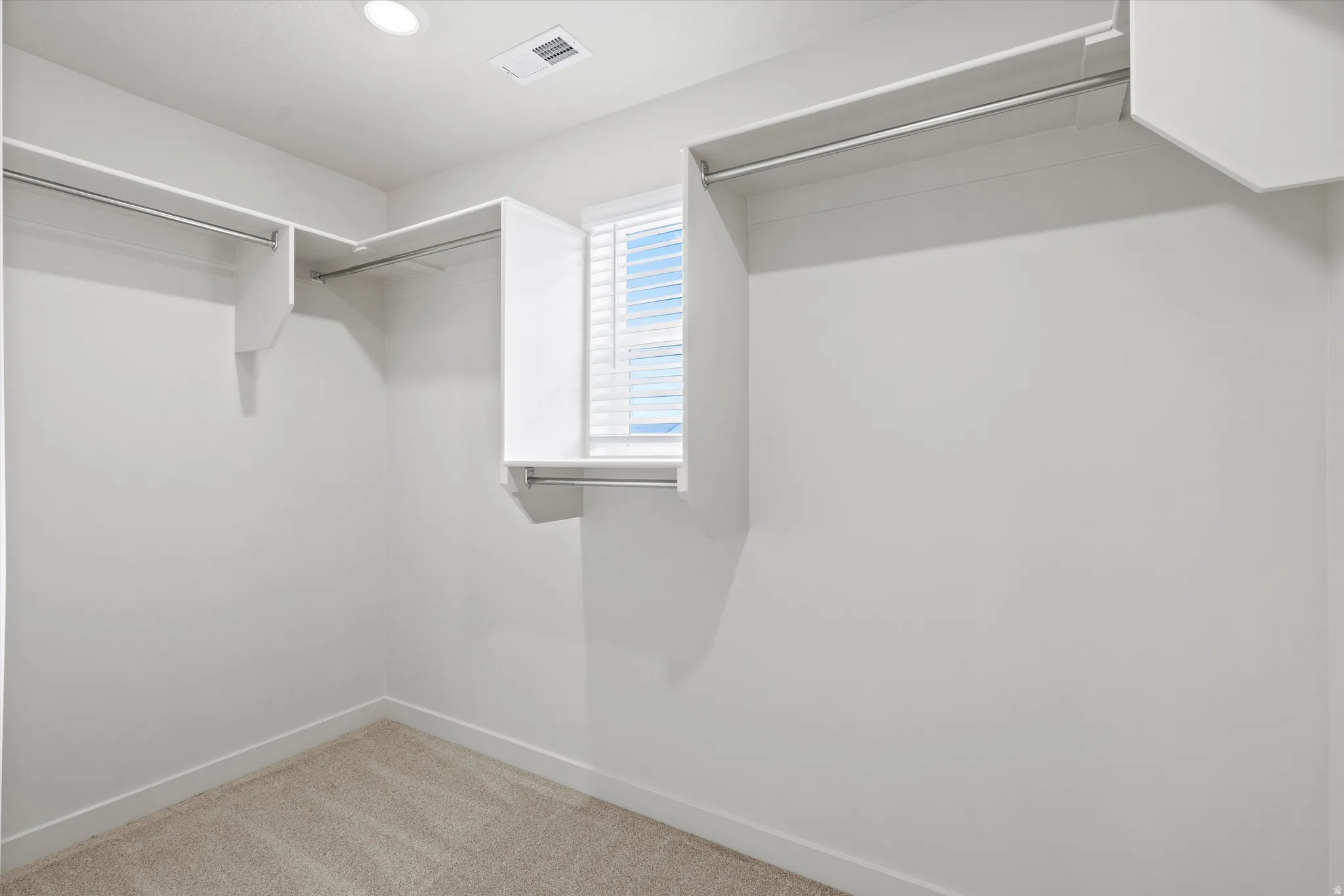 Walk in closet featuring light carpet