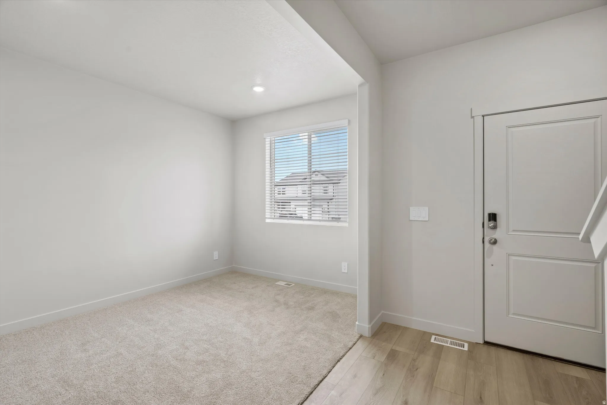 Foyer entrance with light wood-type flooring and recessed lighting