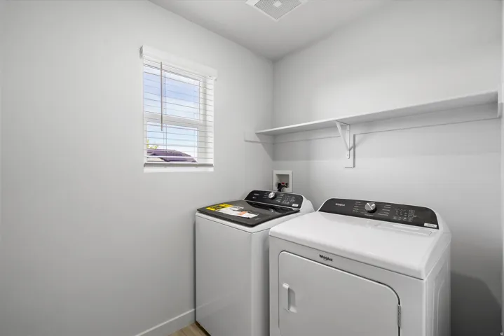 Laundry area featuring washing machine and dryer and baseboards