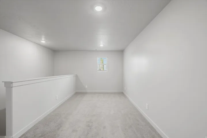 Spare room featuring light colored carpet and recessed lighting