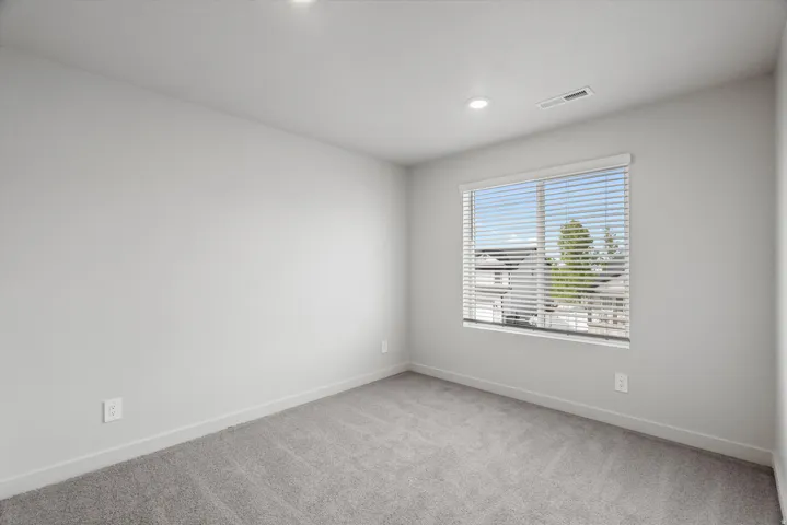Spare room with baseboards and light carpet