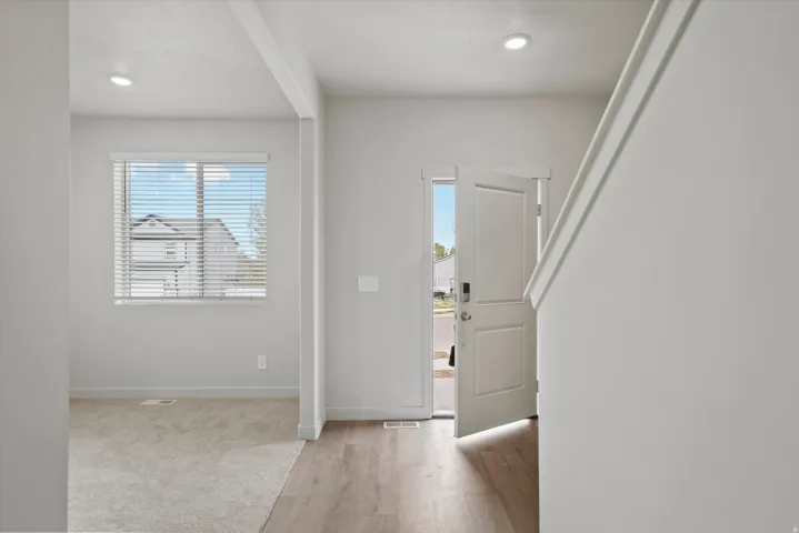 Foyer entrance with light wood finished floors and recessed lighting