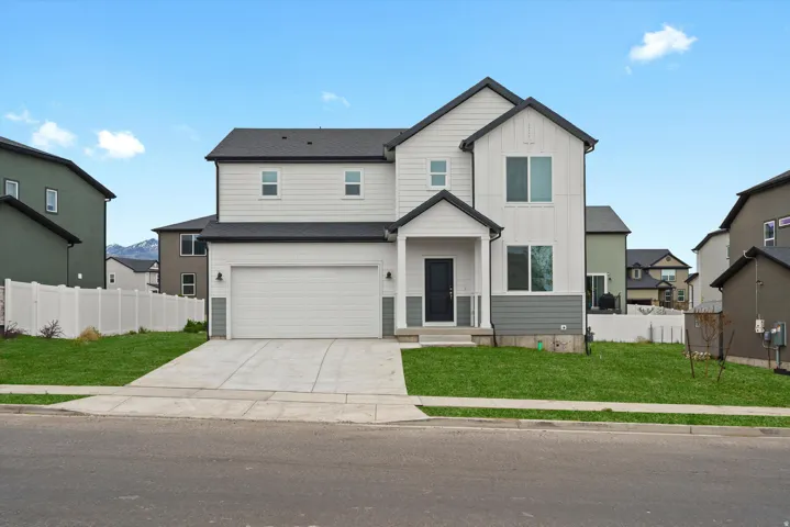 View of front facade with board and batten siding, concrete driveway, and an attached garage