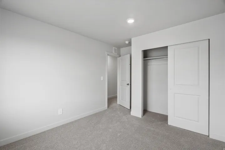 Unfurnished bedroom featuring light colored carpet and a closet