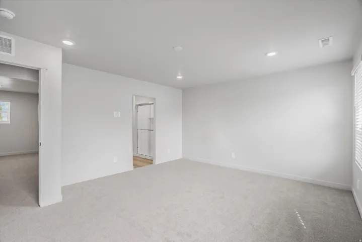 Unfurnished room with light colored carpet, recessed lighting, and a smoke detector
