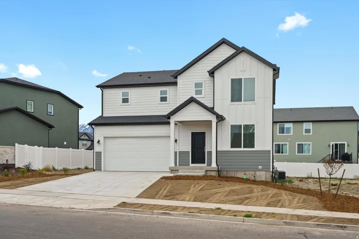View of front of property with board and batten siding, concrete driveway, and a garage