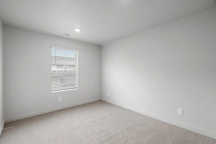 Empty room featuring light colored carpet and baseboards