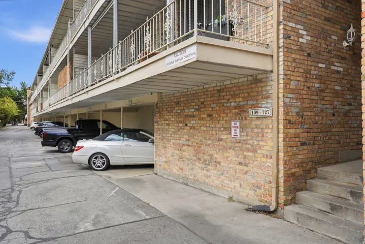 View of side of property featuring brick siding and covered parking