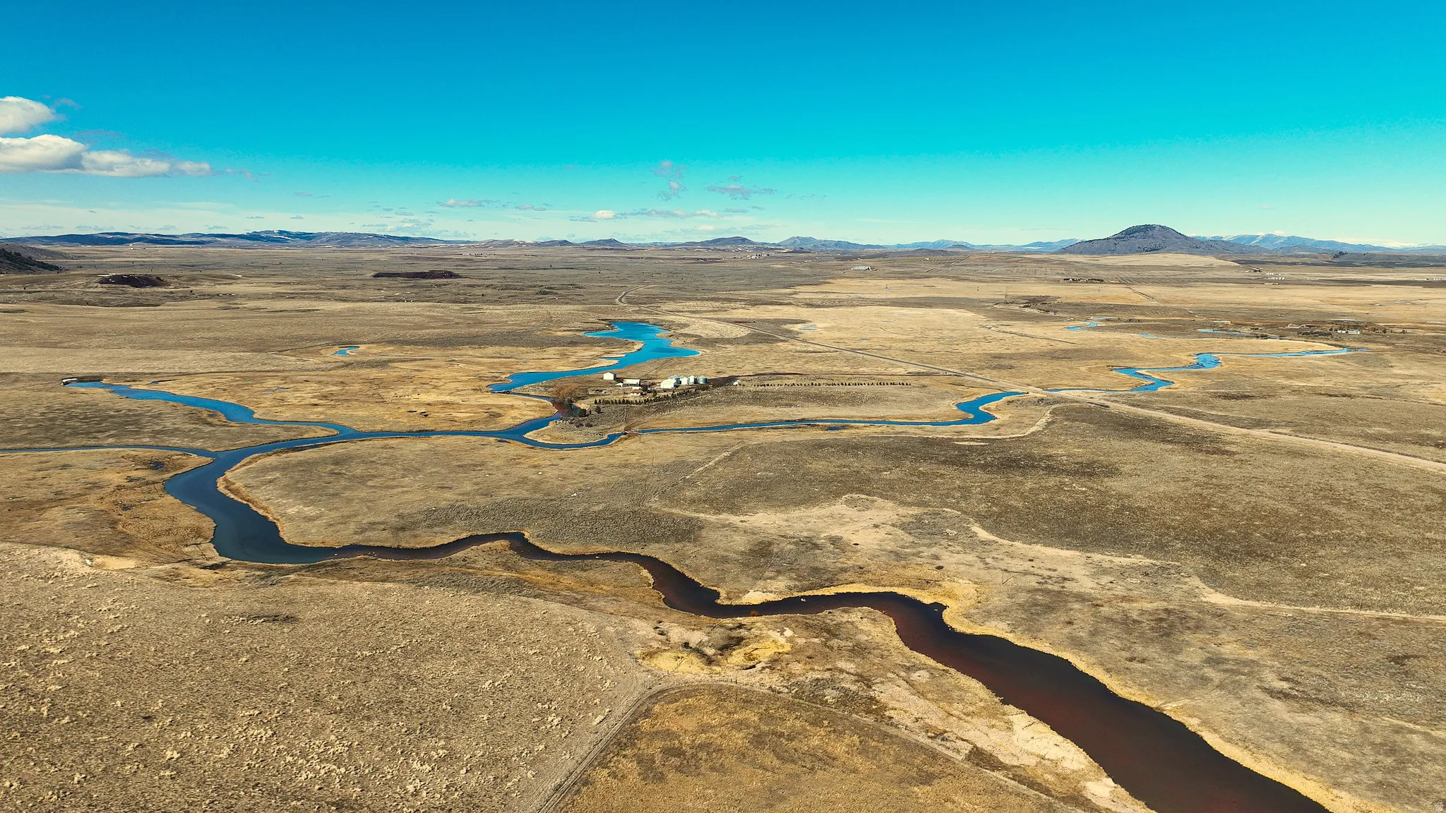View of rural area featuring a mountain backdrop and a desert landscape