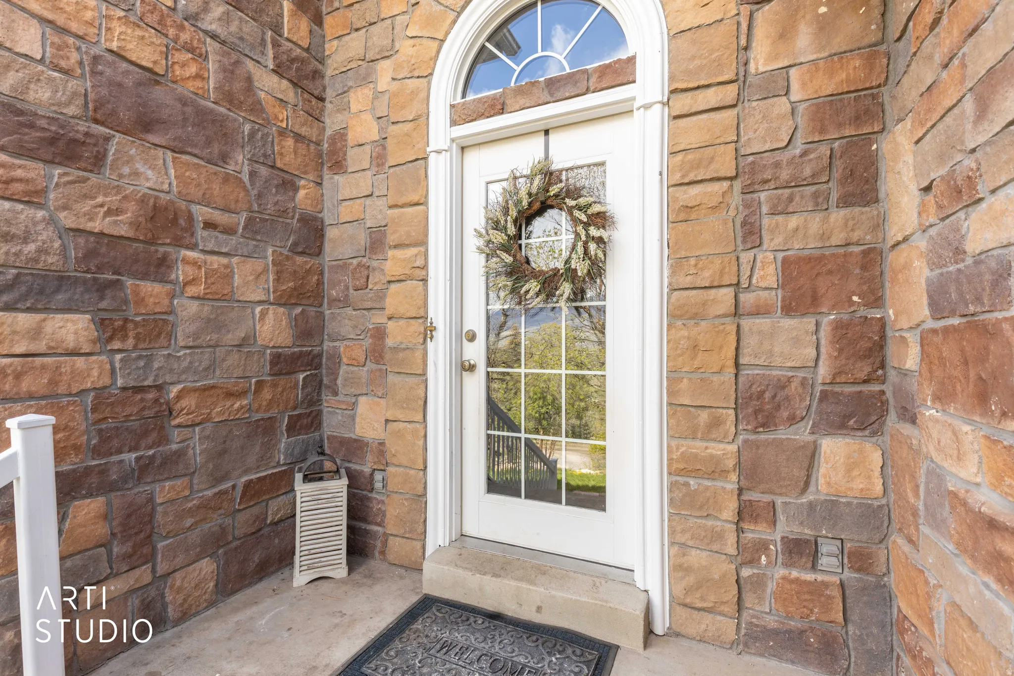 Property entrance featuring brick siding and stone siding