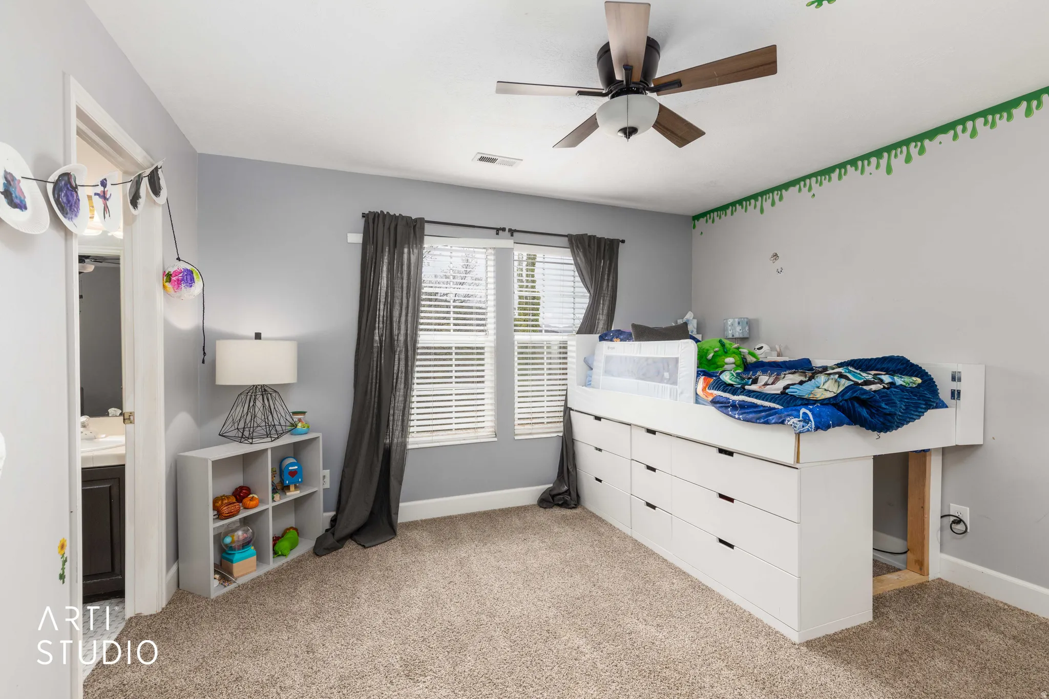 Bedroom featuring light carpet, ceiling fan, and ensuite bathroom