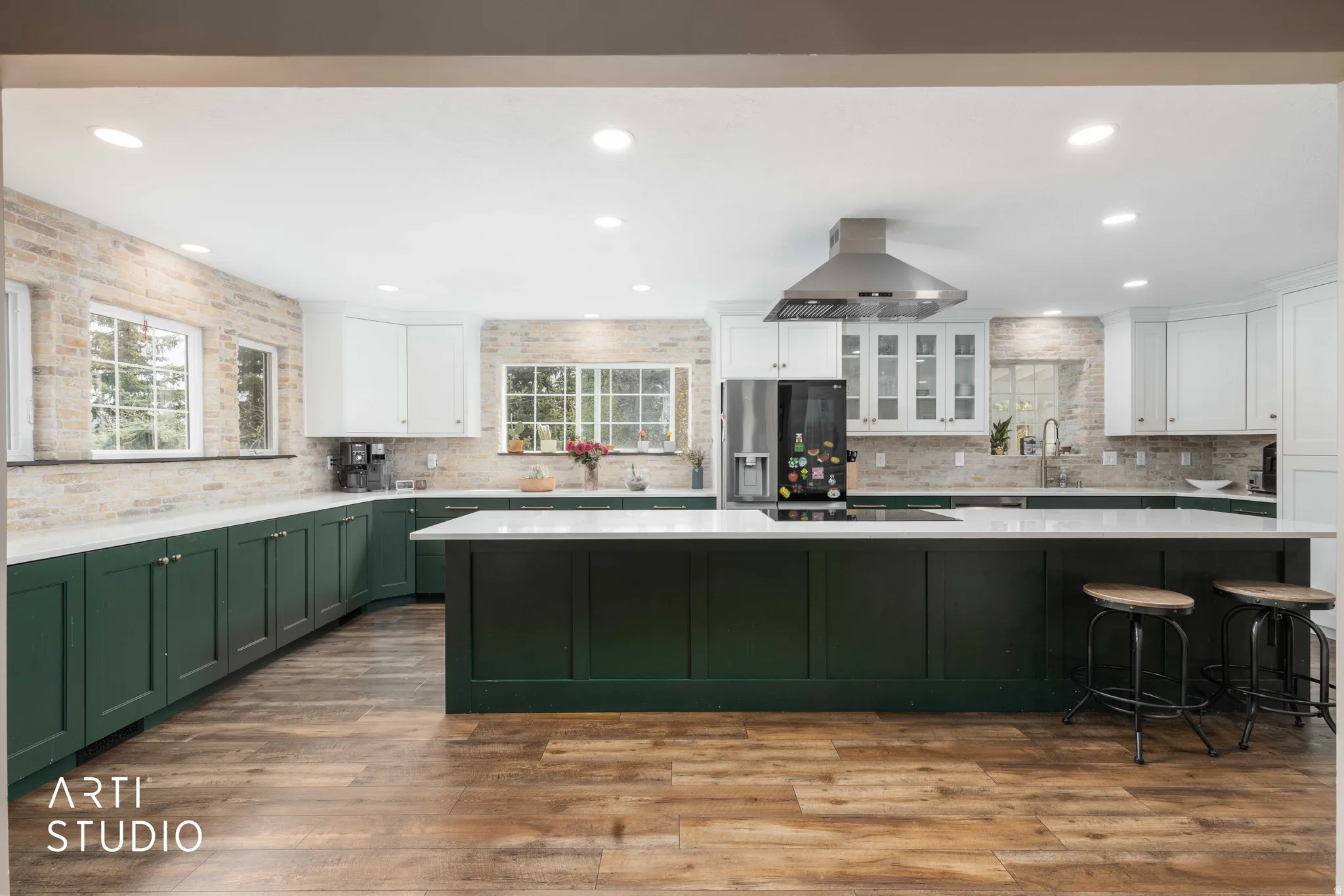Dual tone kitchen featuring two tone cabinets, stainless steel refrigerator with ice dispenser, recessed lighting, island exhaust hood, and dark wood finished floors