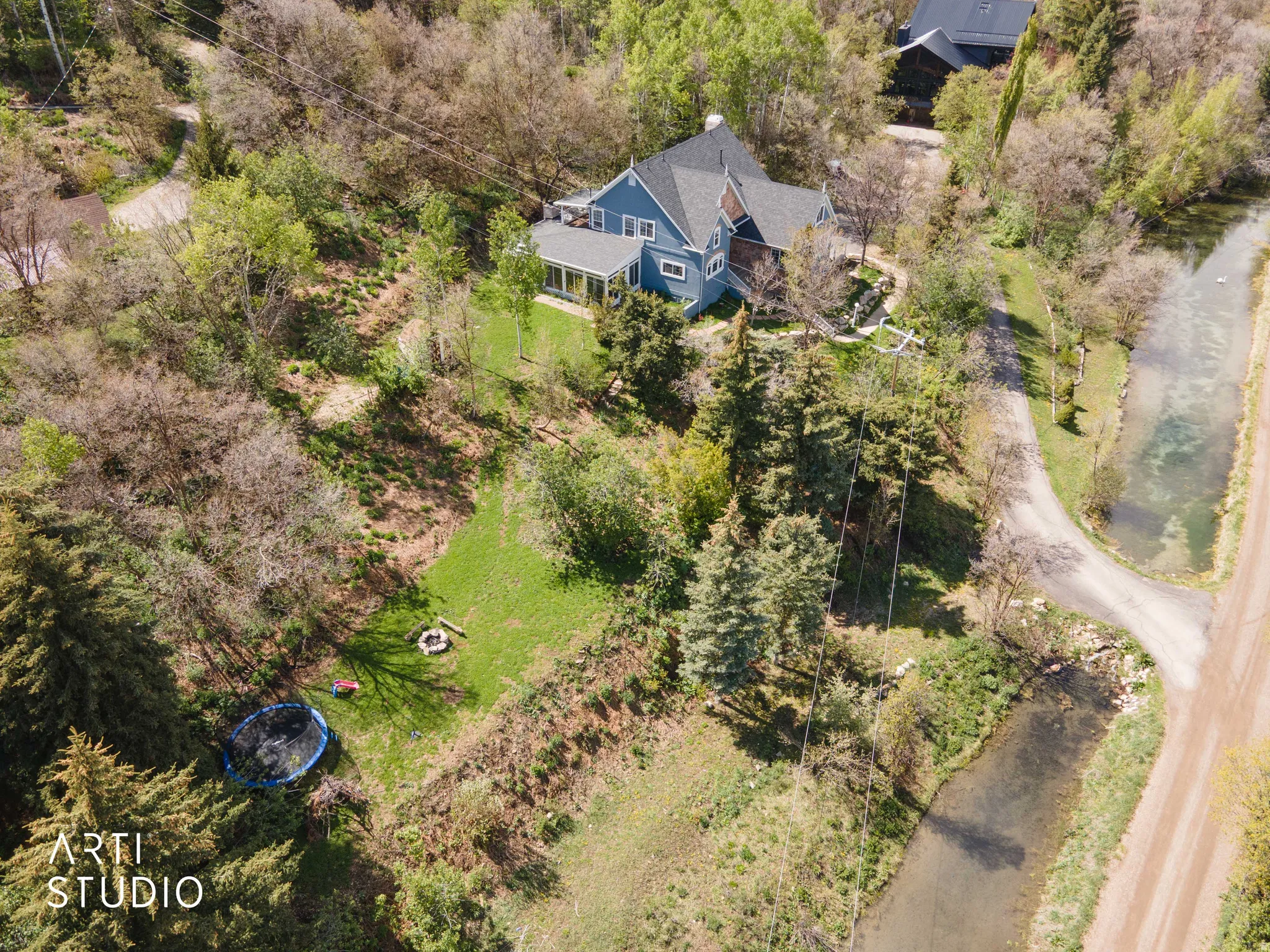Aerial view of property and surrounding area with a tree filled landscape