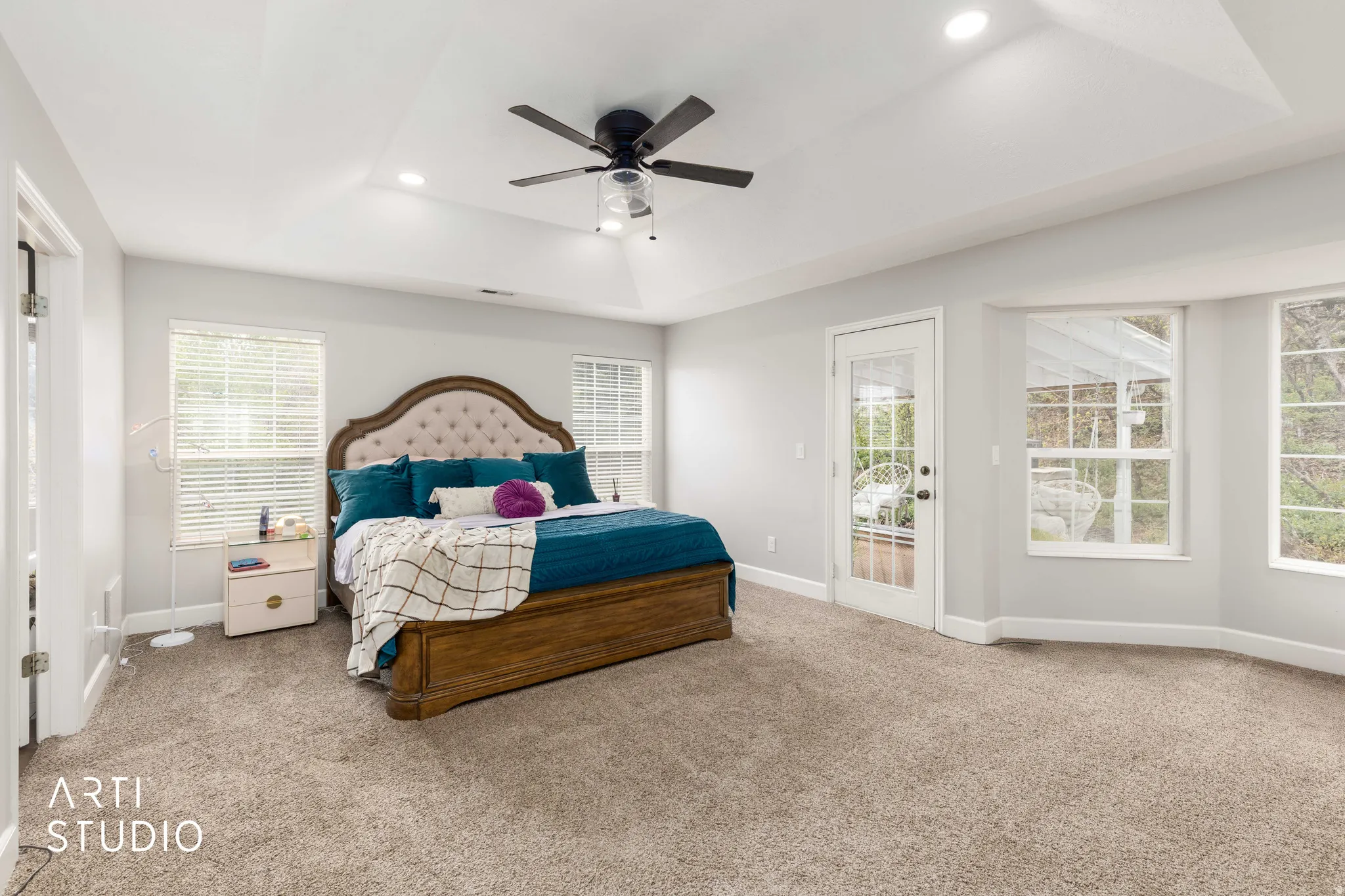 Bedroom featuring access to outside, a tray ceiling, light colored carpet, ceiling fan, and recessed lighting