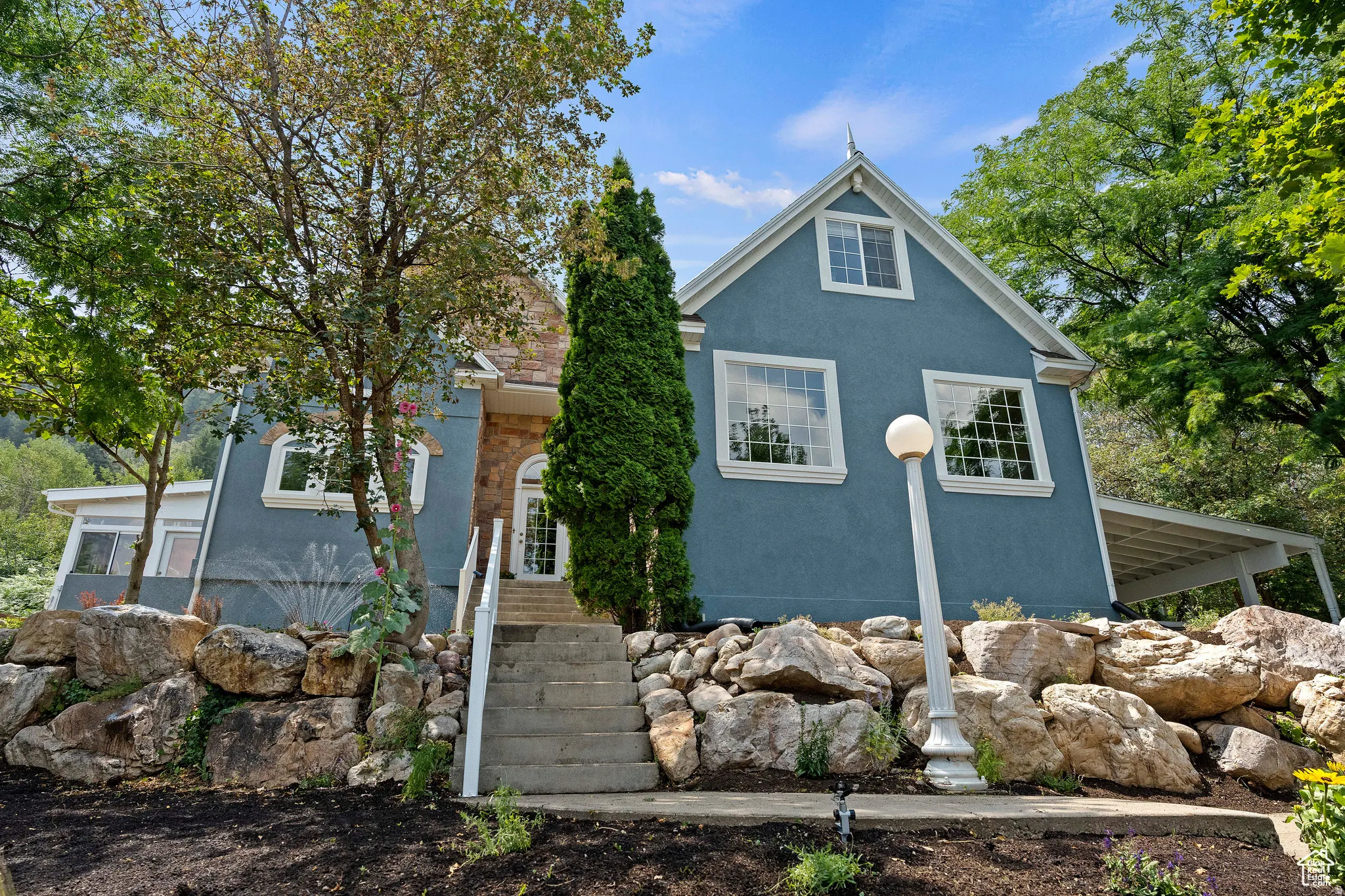 Two-story residence featuring a blue exterior and a stone facade accent