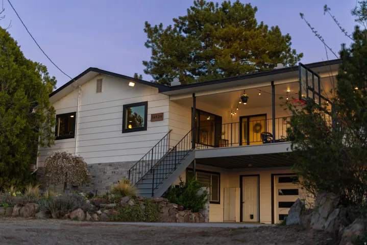 View of front of house featuring a balcony and stairway