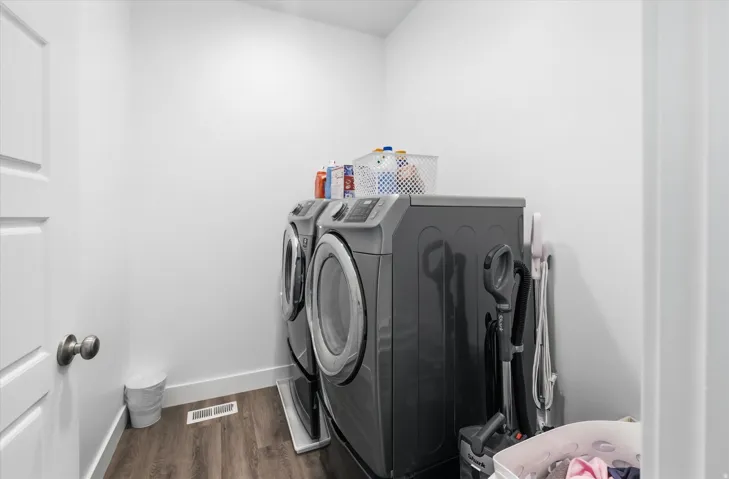 Laundry area featuring washer and clothes dryer and dark wood-style flooring