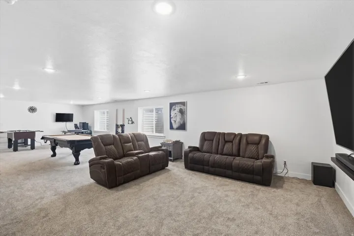 Downstairs Living area featuring light colored carpet, billiards table, recessed lighting, and a textured ceiling