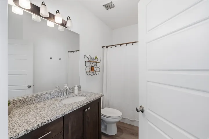 Full bath 2 with vanity, curtained shower, and dark wood finished floors