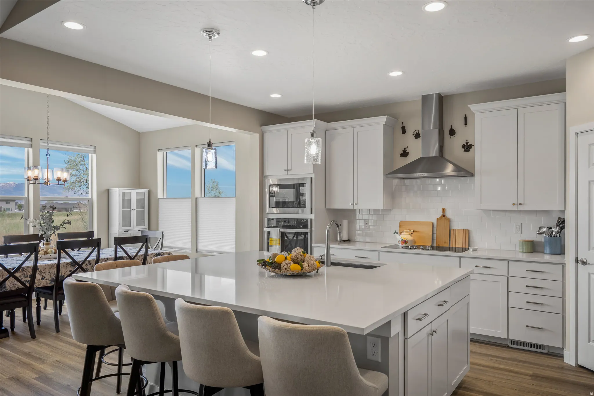 Kitchen featuring white cabinetry, stainless steel appliances, dark wood-type flooring, vaulted ceiling, and tasteful backsplash