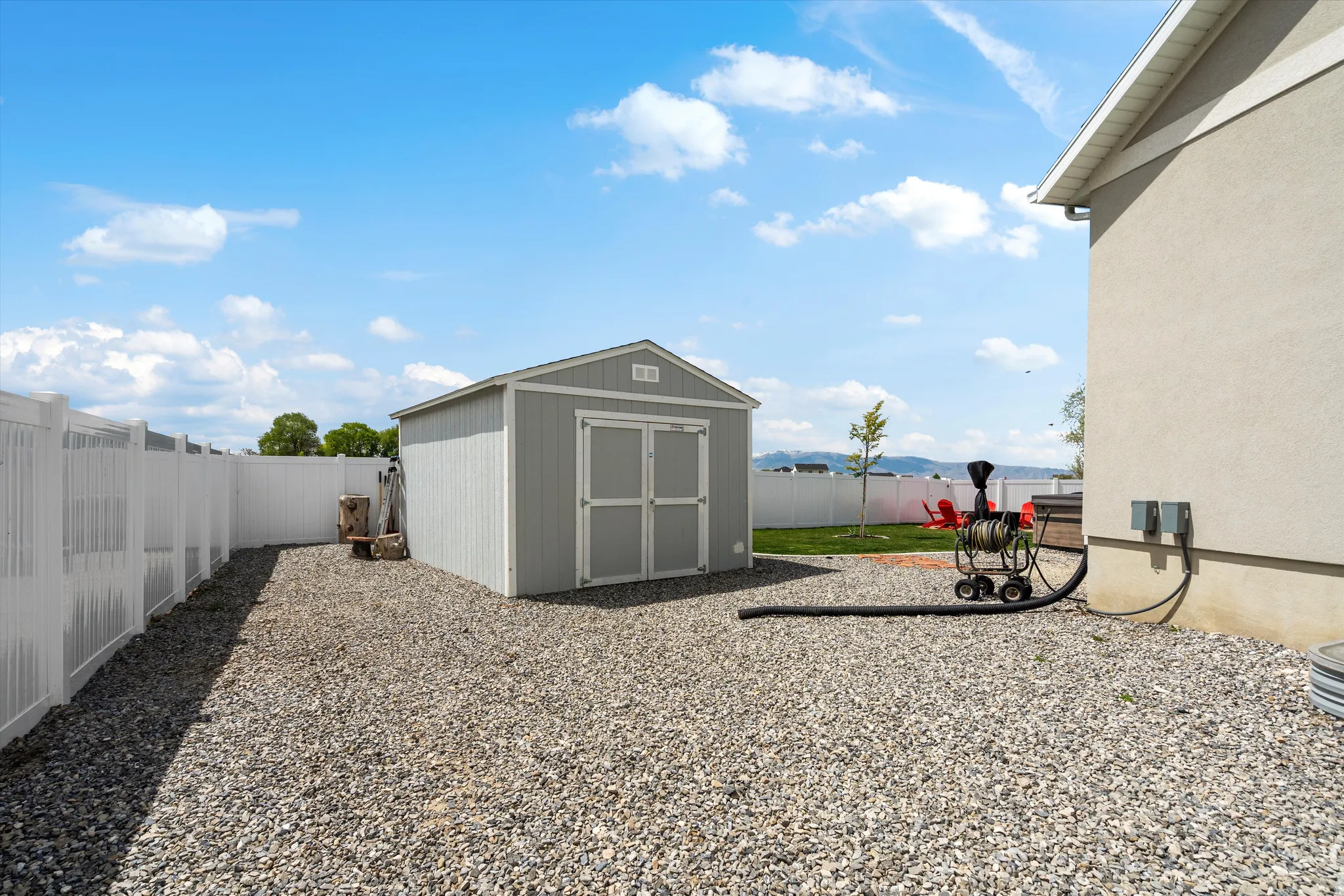 Fenced backyard with a storage unit and a mountain view
