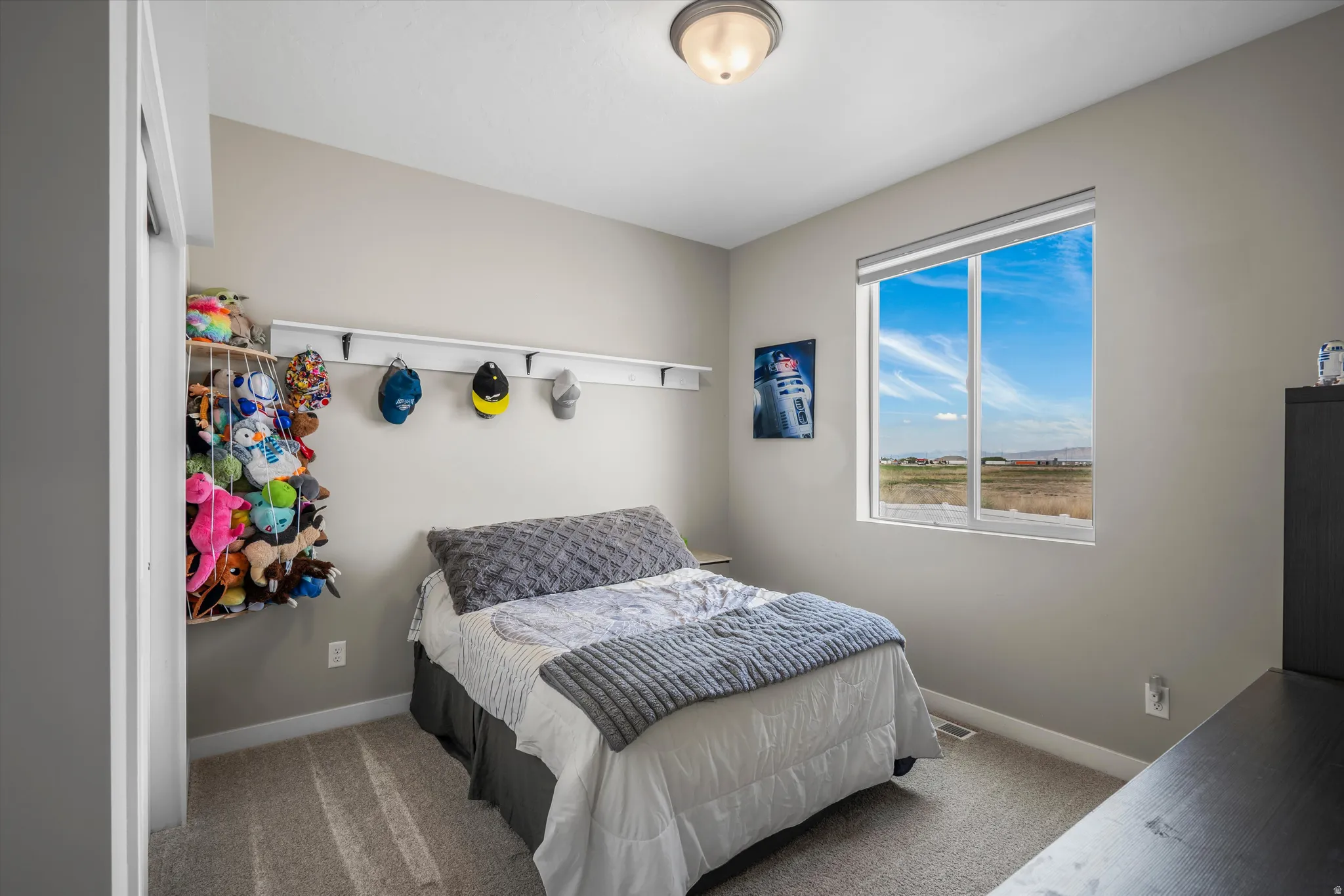 Bedroom with light colored carpet and baseboards